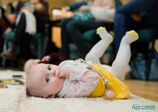 Baby lying on mat with legs in the air
