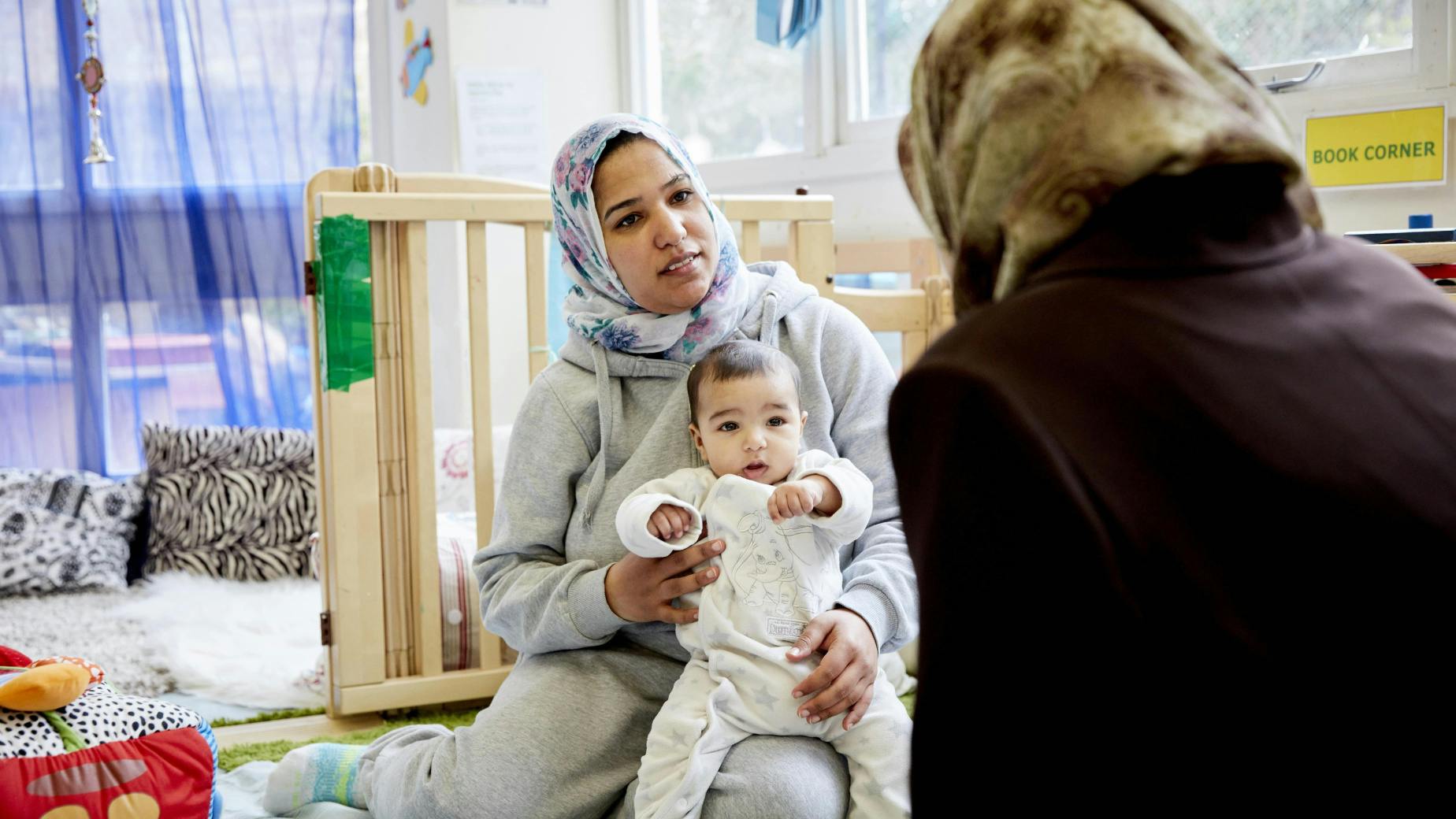 Mother wearing hijab holding her baby