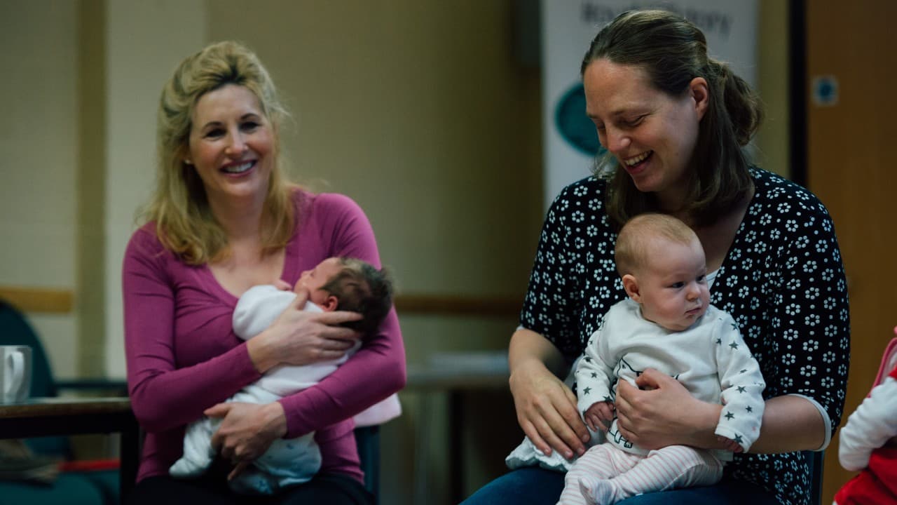 Two mums smiling with their babies